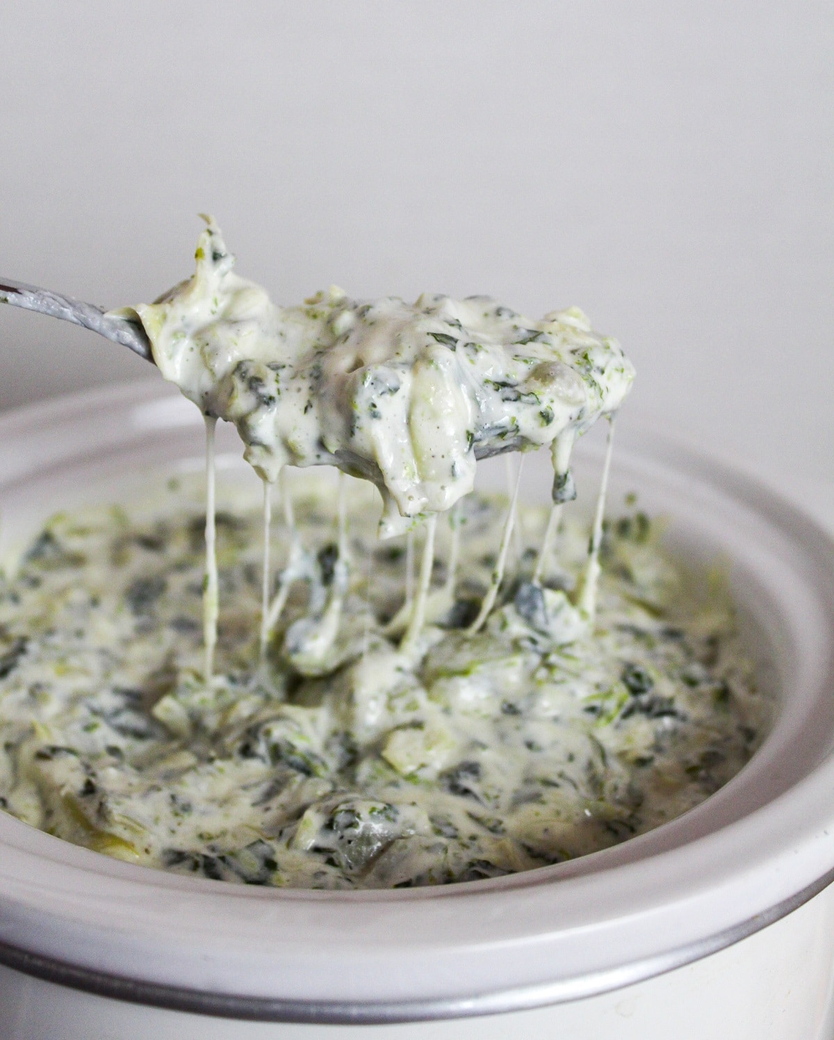spinach and artichoke dip on a spoon