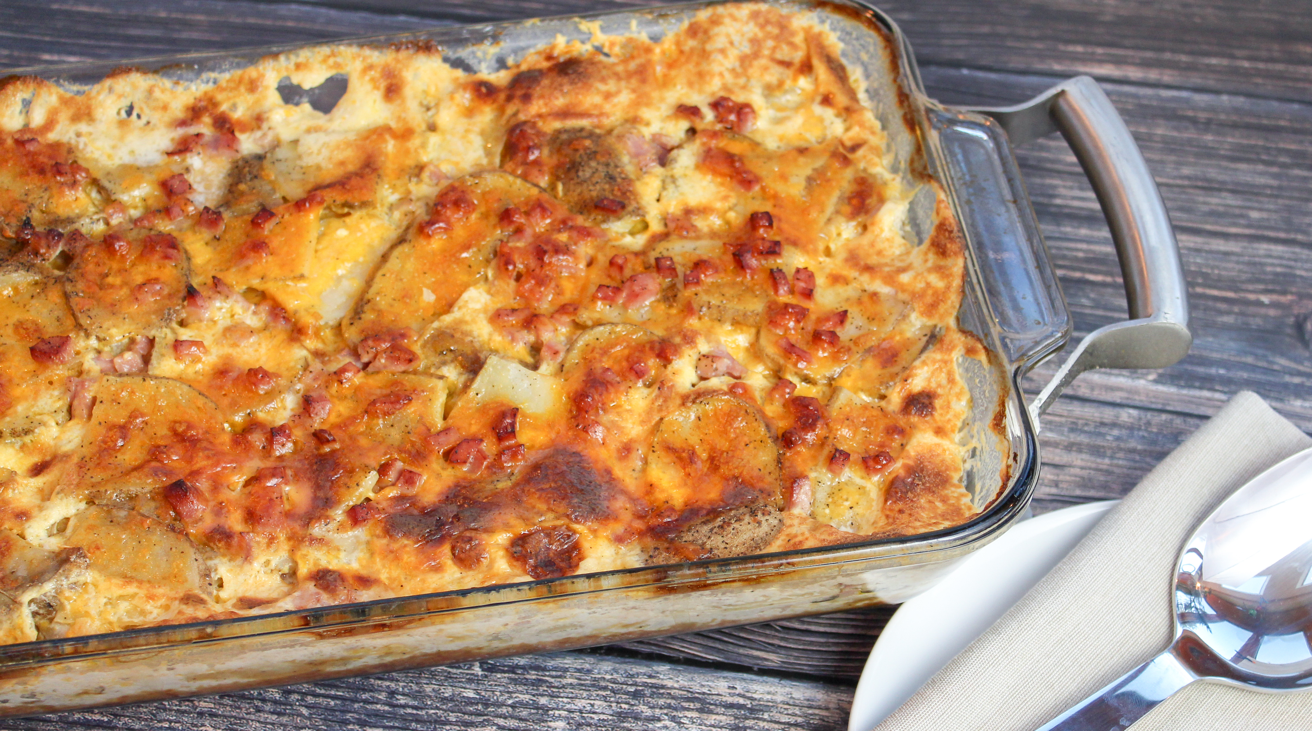 Sliced potatoes, cheese, and diced ham baked in a casserole dish