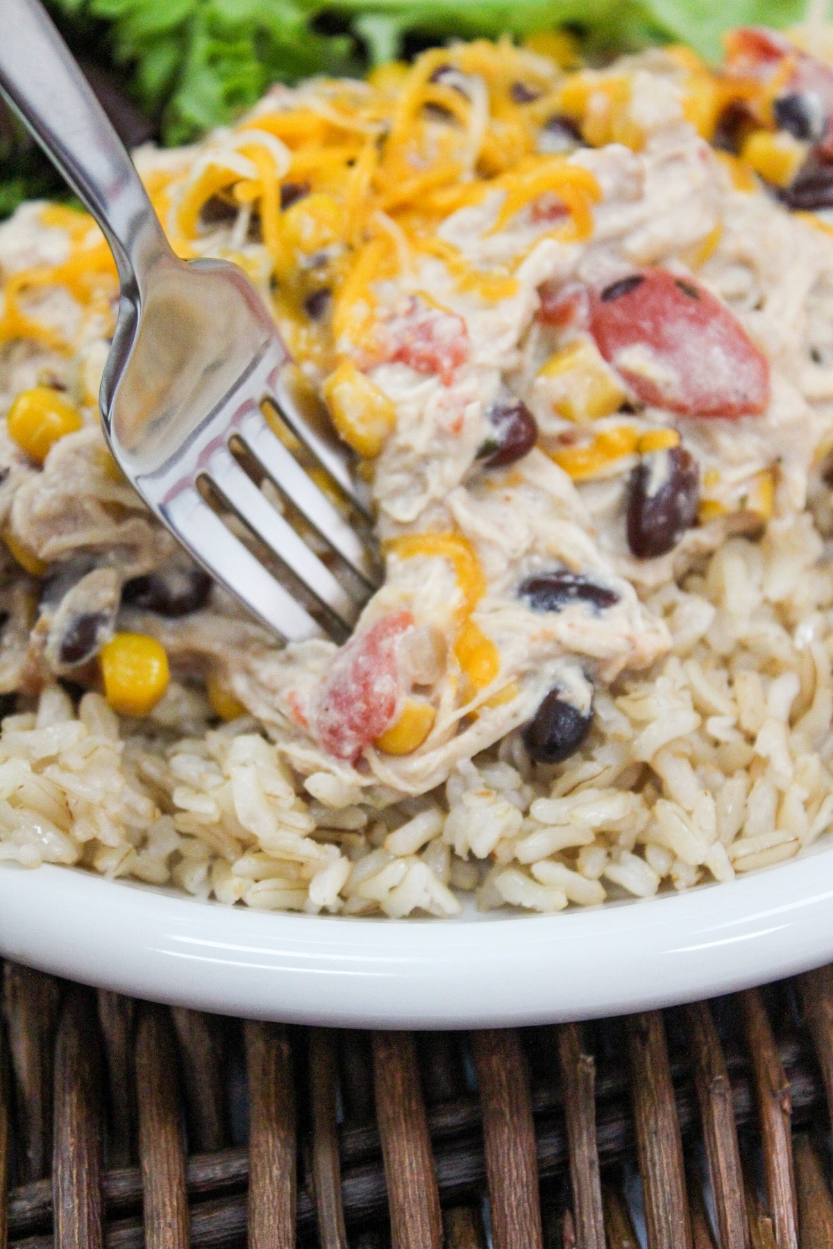Slow Cooker Cream Cheese Chili Chicken plated over rice with a fork