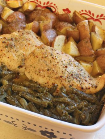 chicken in a baking dish with potatoes and green beans