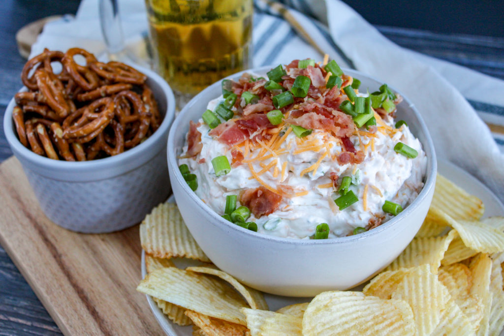 beer dip in a bowl with chips and pretzels