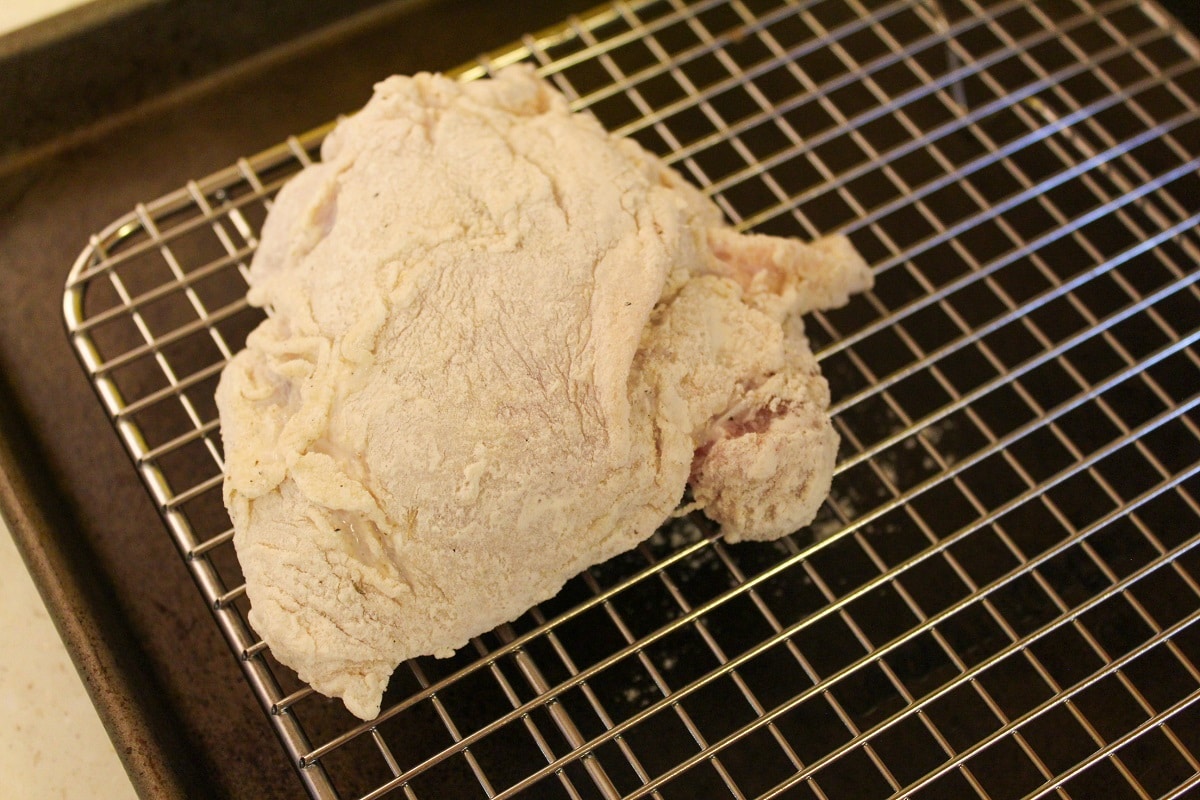 uncooked chicken on a baking rack