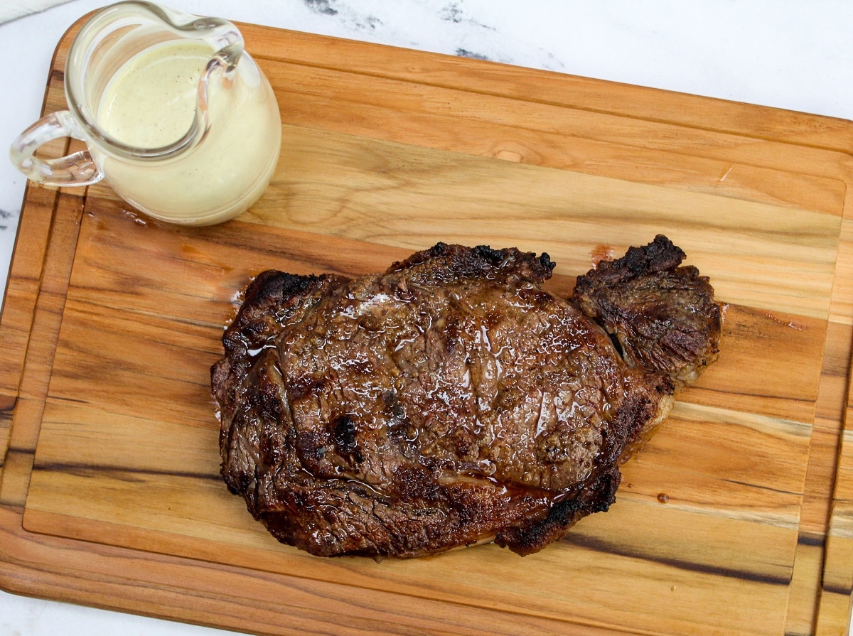 Grilled Ribeye with Garlic Blue Cheese Mustard Sauce on a cutting board
