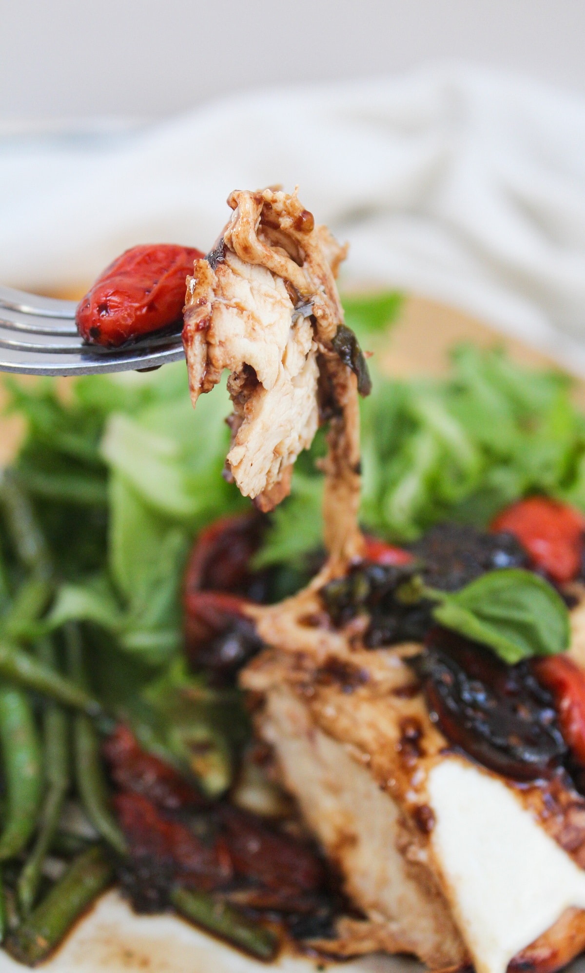 grilled caprese chicken cut and on a fork.