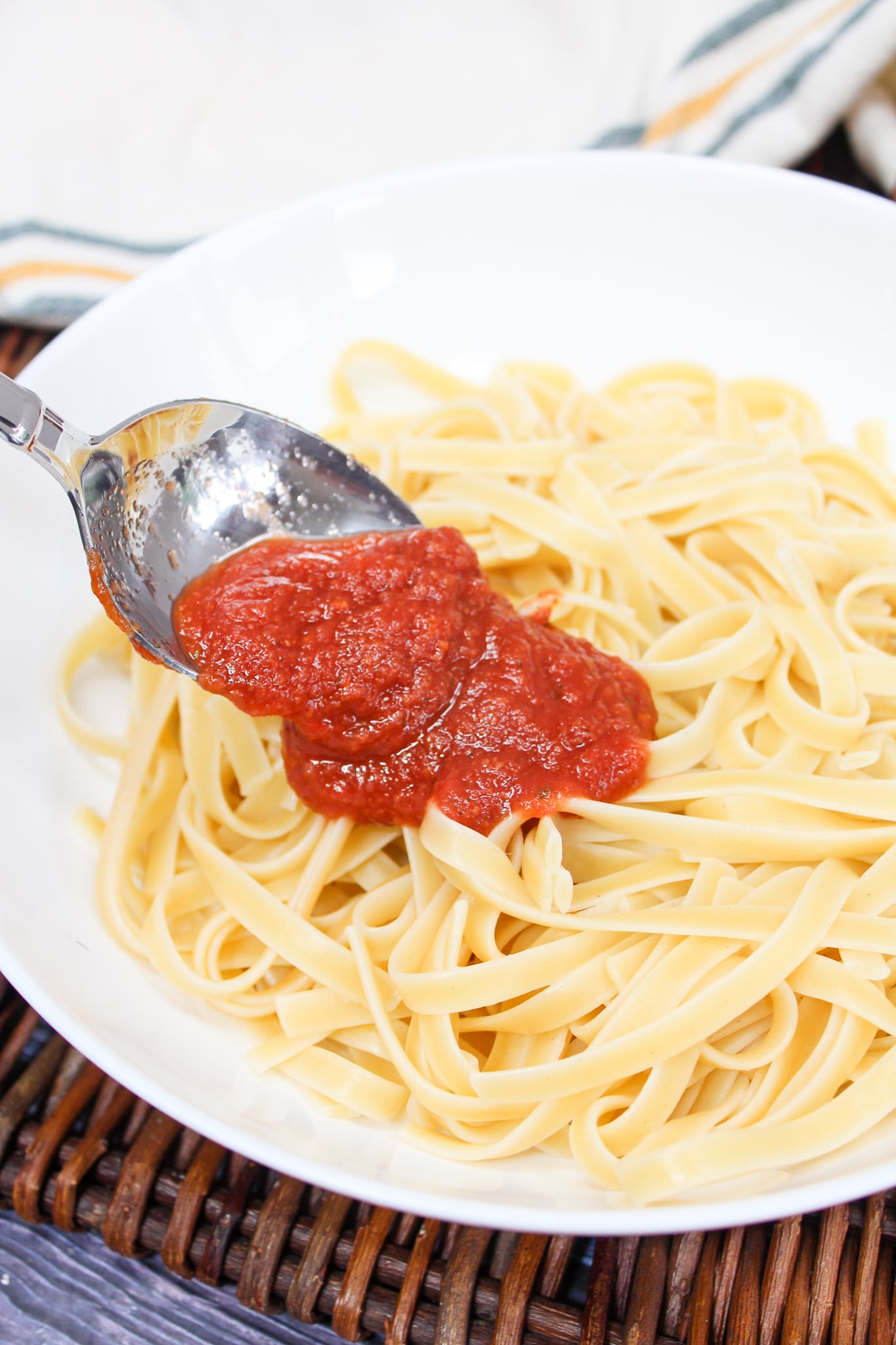 pasta sauce spooned over cooked pasta