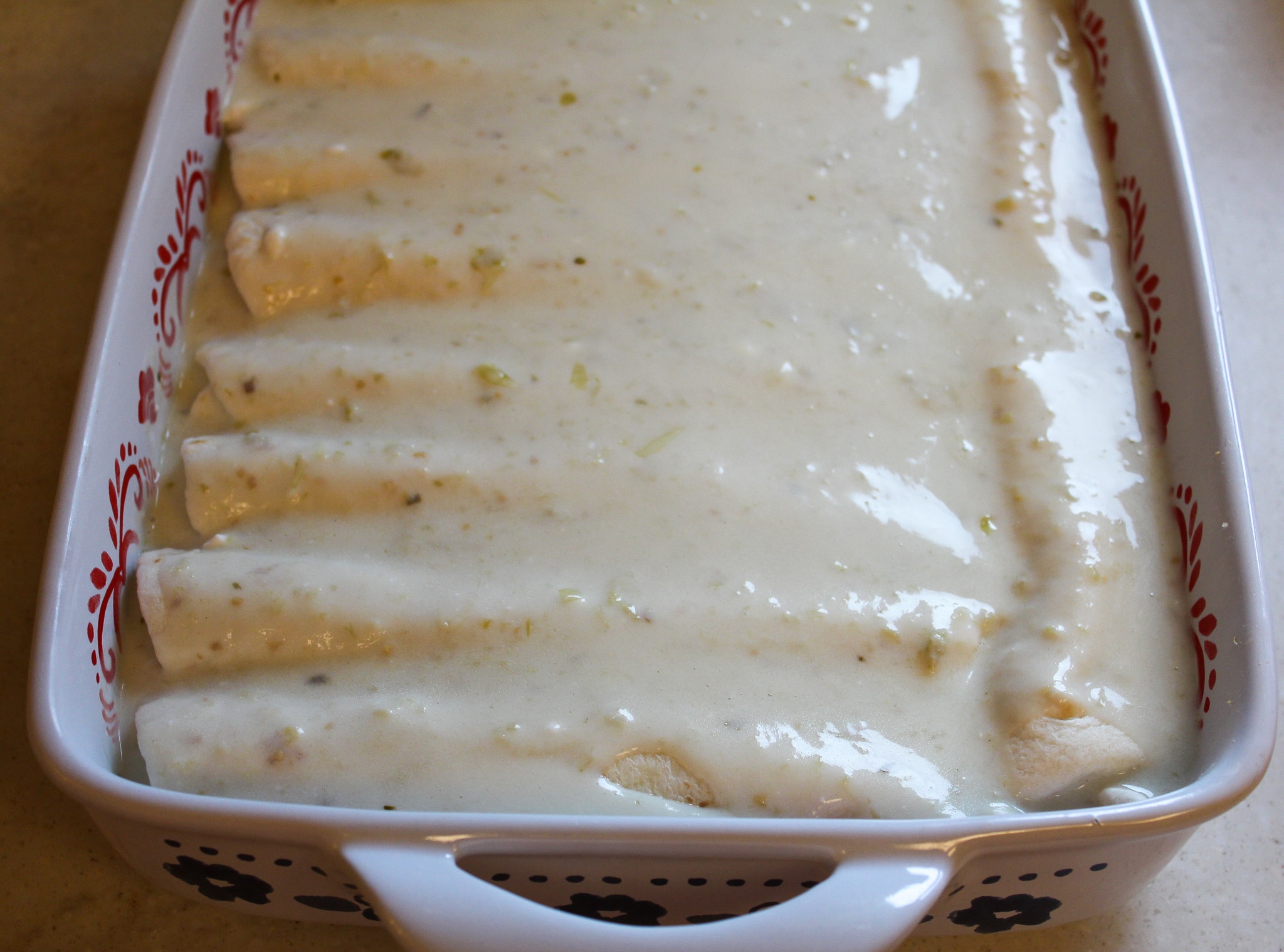 enchiladas in a baking dish with sauce