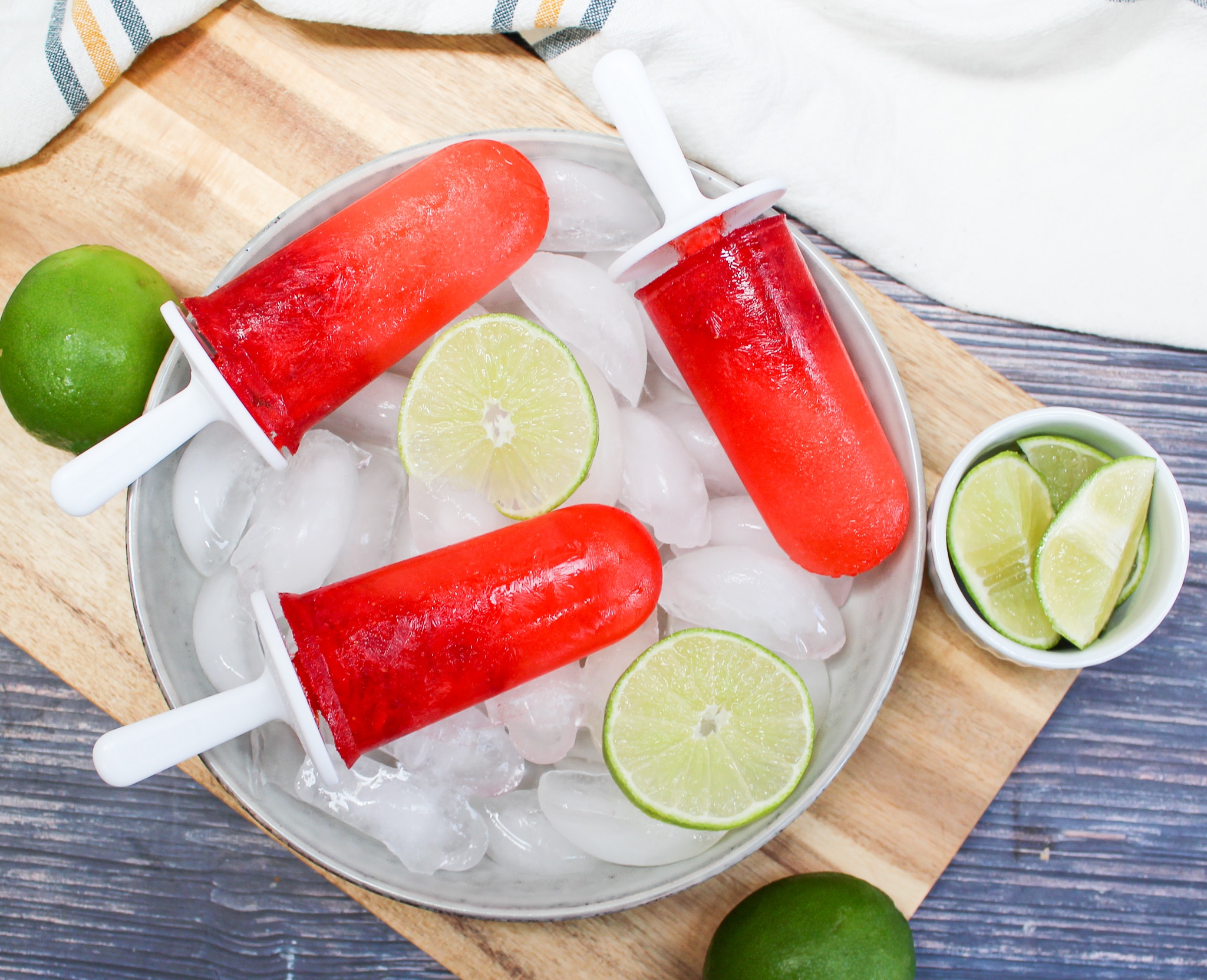 Strawberry Margarita Popsicle over ice with limes