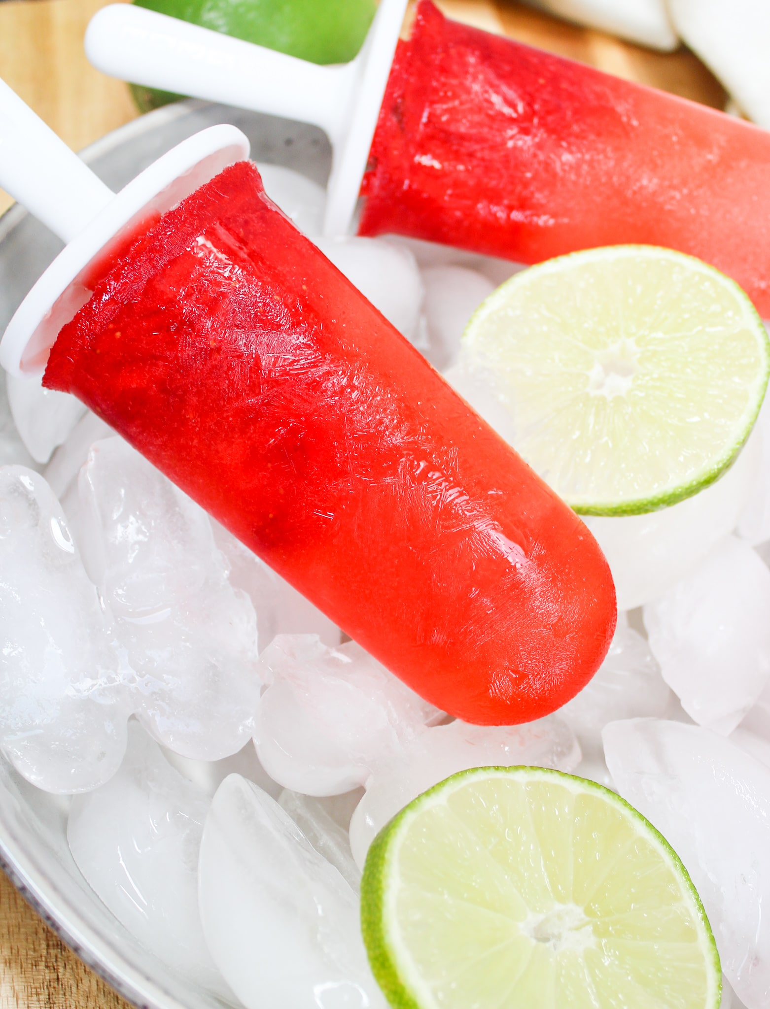 Strawberry Margarita Popsicle over ice with limes