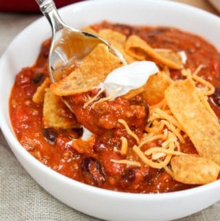 chili in a bowl with corn chips and spoon