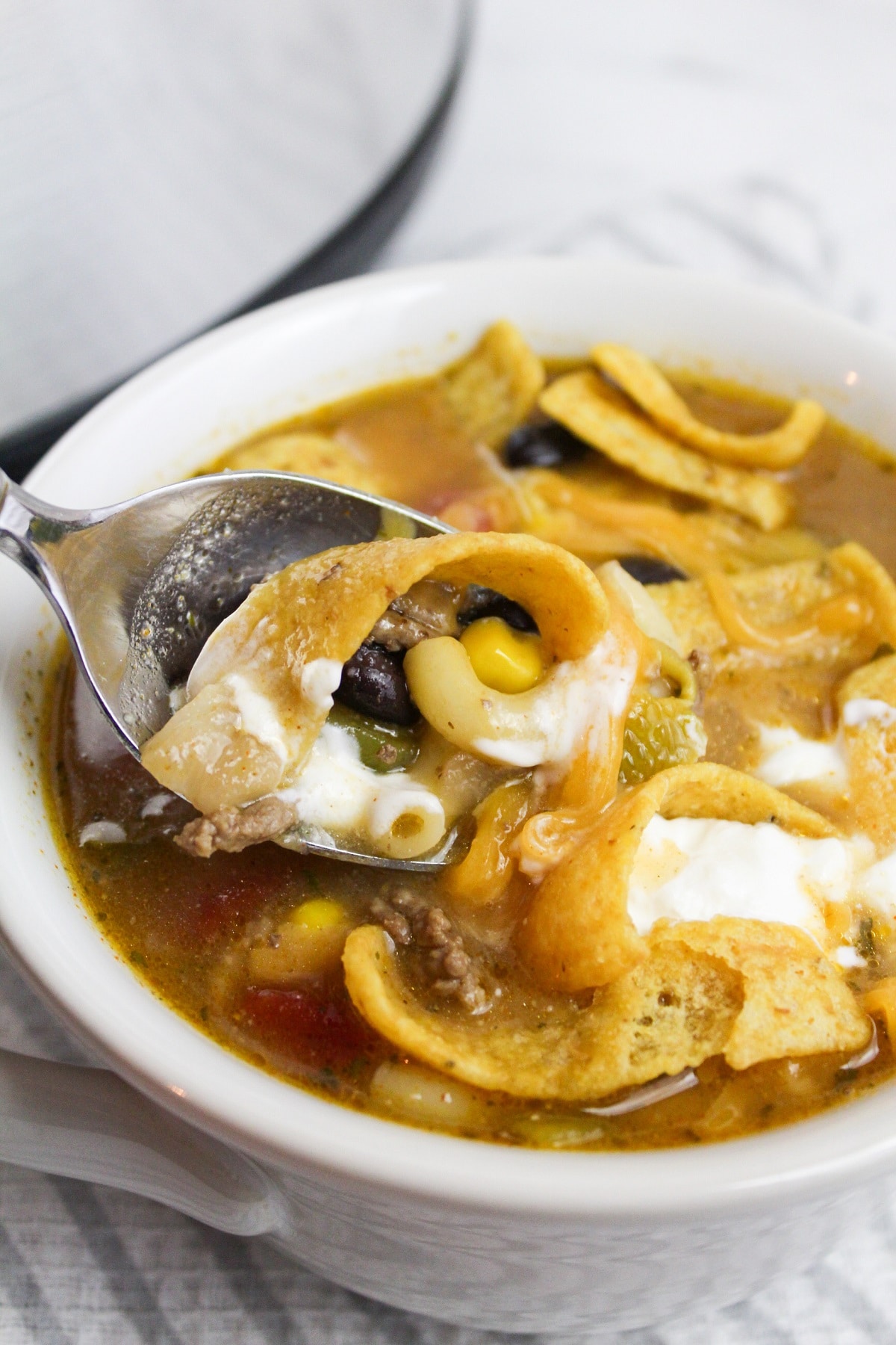 taco soup in bowl with sour cream and fritos