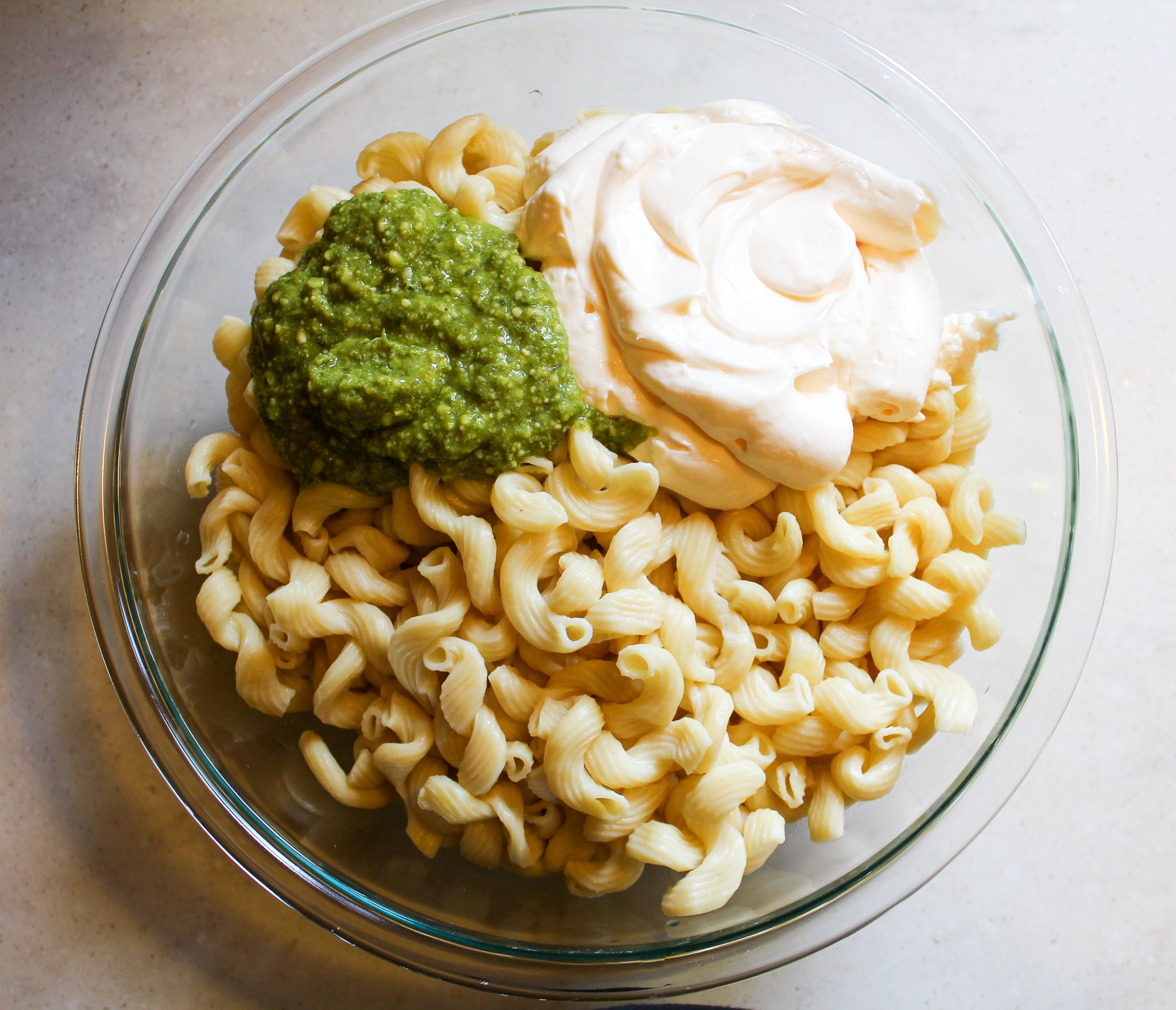 bowl of plain noodles with mayo and pesto