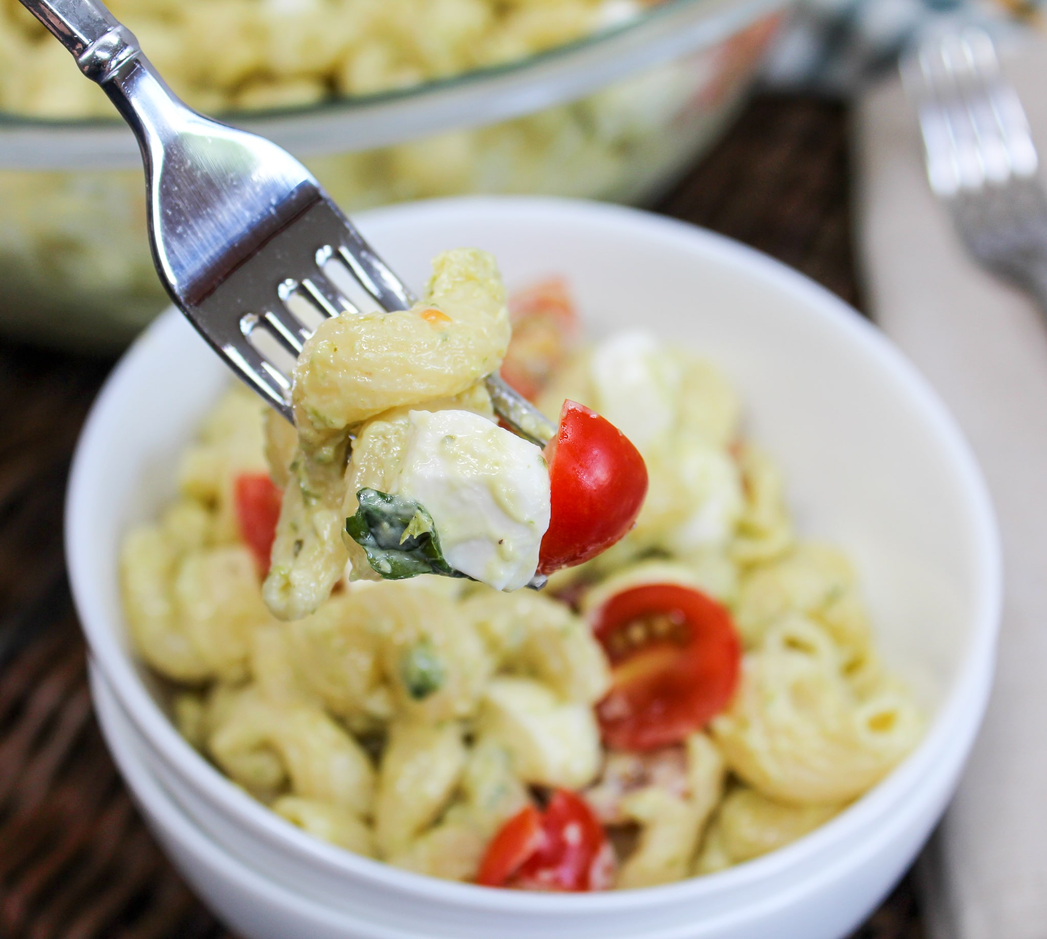 pasta salad in white individual bowls with a fork