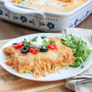 Portion of chicken tamale casserole with cheese on a plate with a side salad