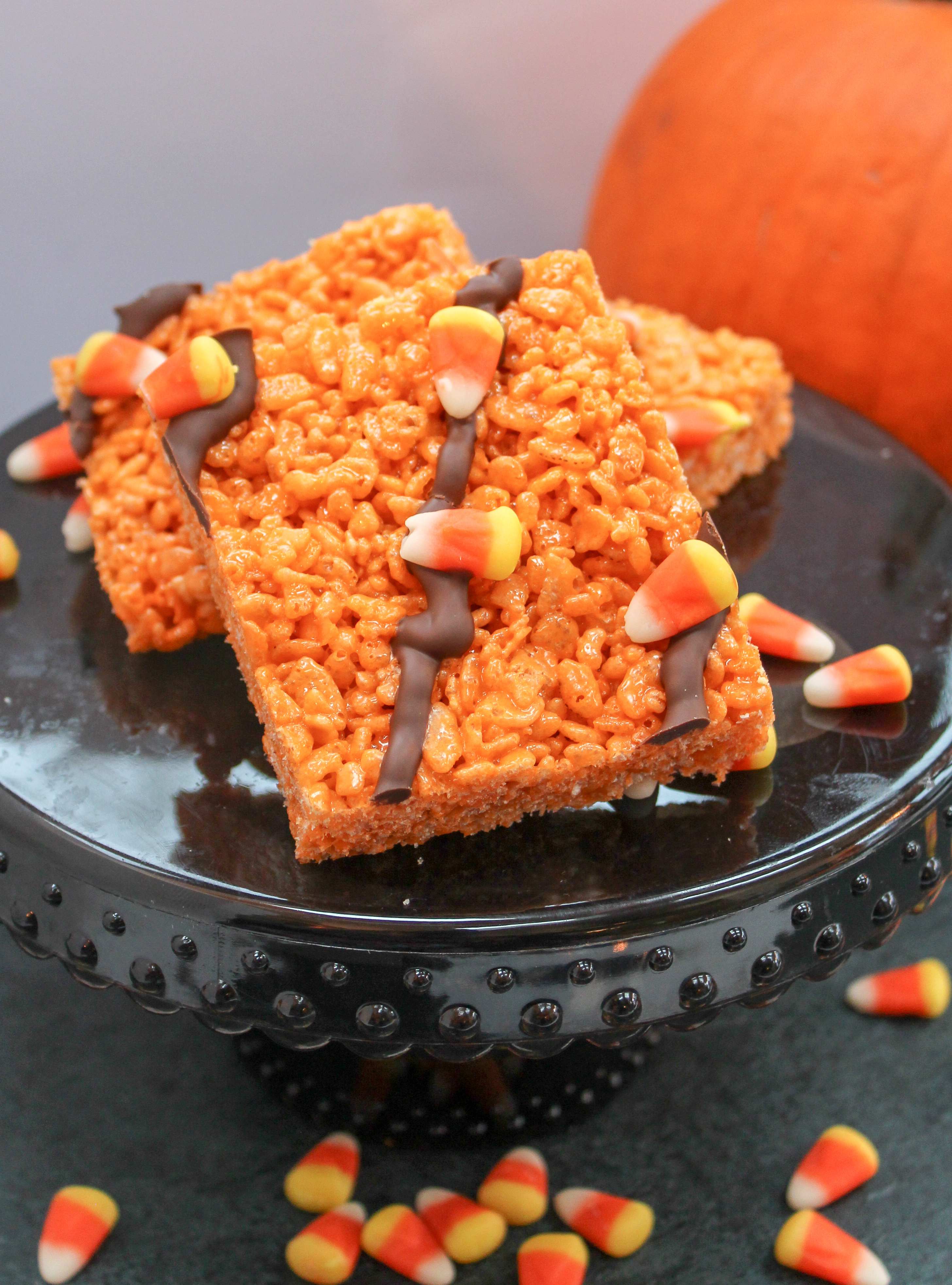 Rice Crispy Cereal cut into squares. Garnished with Candy Corn and Chocolate