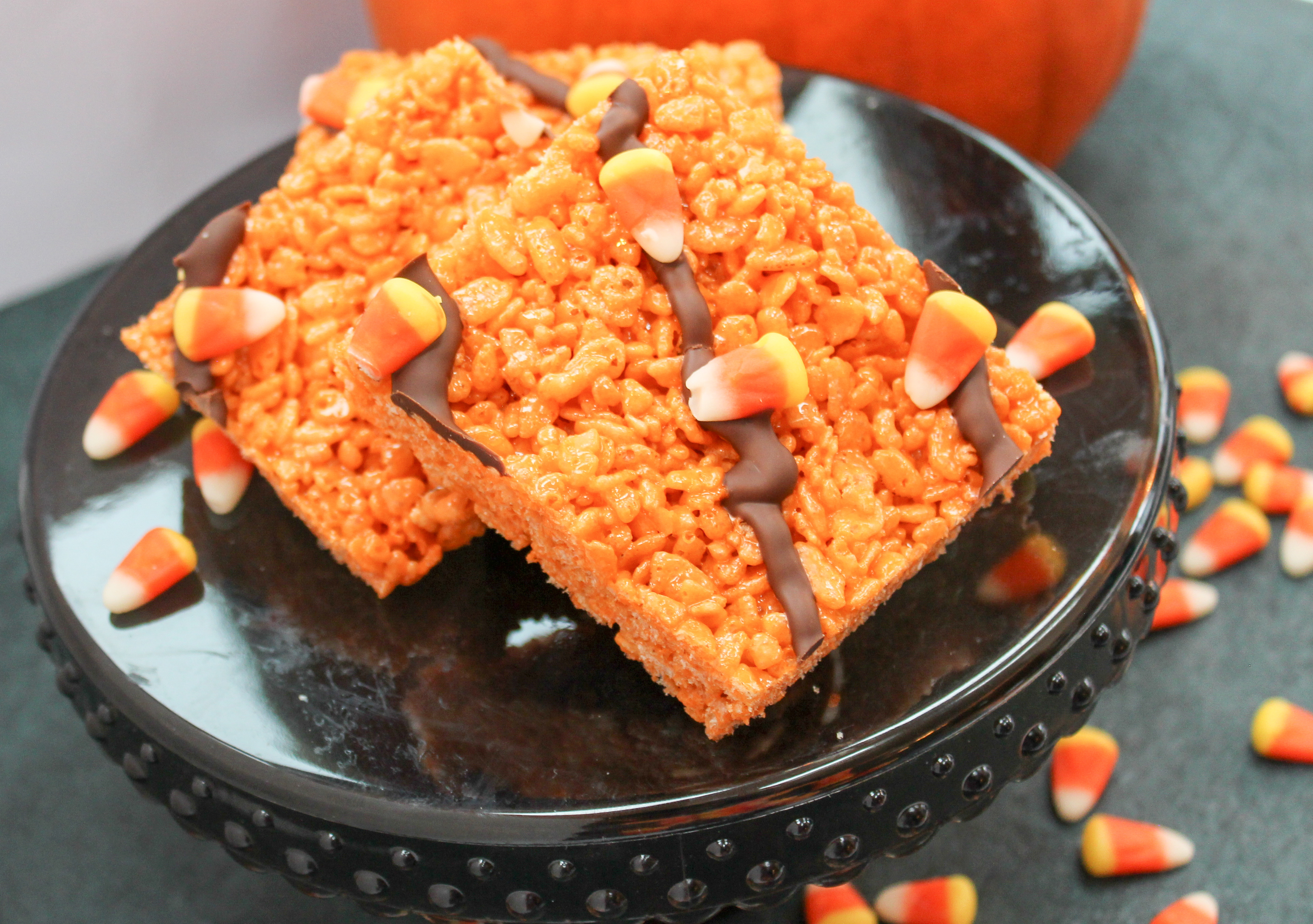 Rice Crispy Cereal cut into squares. Garnished with Candy Corn and Chocolate