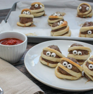 Meatballs wrapped in a strip of dough with candy eyes
