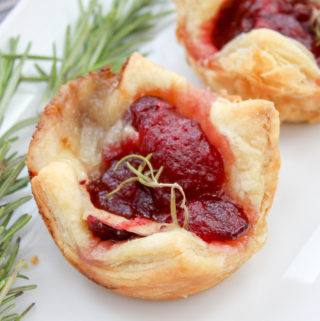 Cranberry and brie cheese in baked puffed pastry topped with rosemary