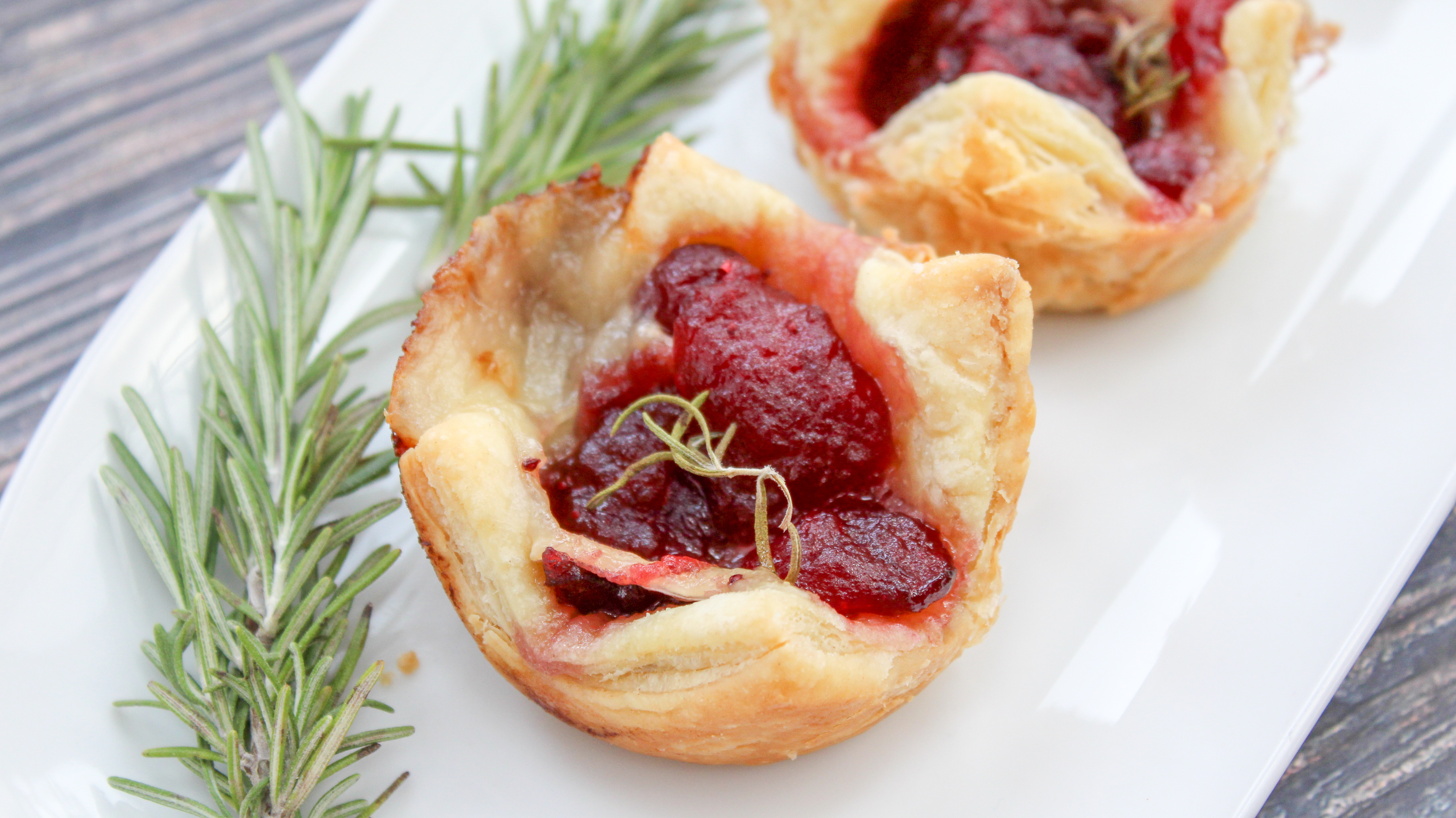 Cranberry and brie cheese in baked puffed pastry topped with rosemary