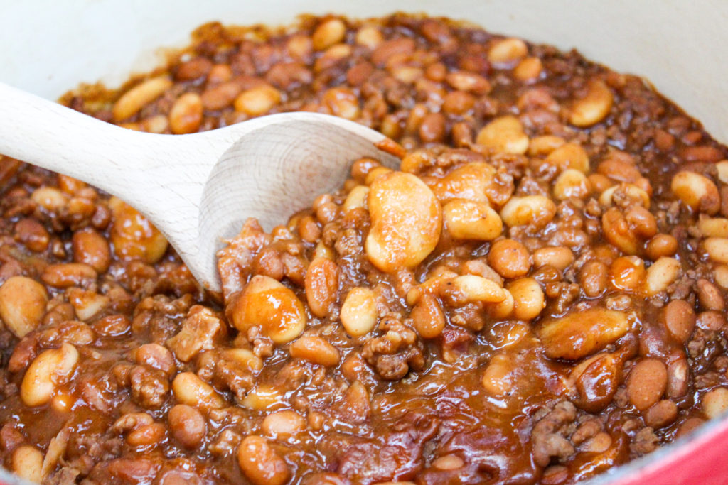 Baked beans in a pot with a wooden spoon