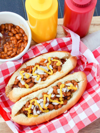 hot dog on the bun with beans and onion