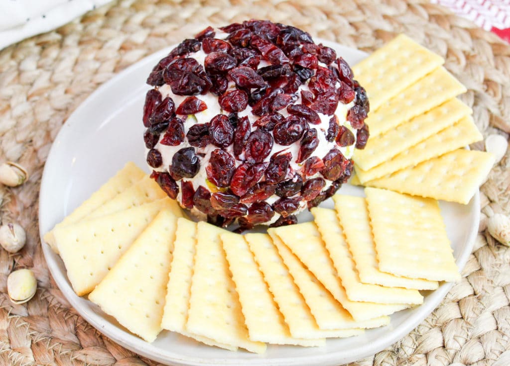 cheese ball on a plate with crackers around it