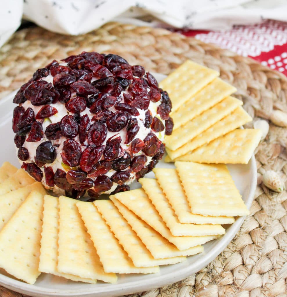 cheese ball on a plate with crackers around it