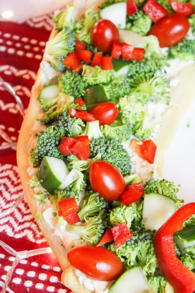 Close-up of veggies on the veggie pizza- broccoli, tomatoes, pepper, and cucumbers