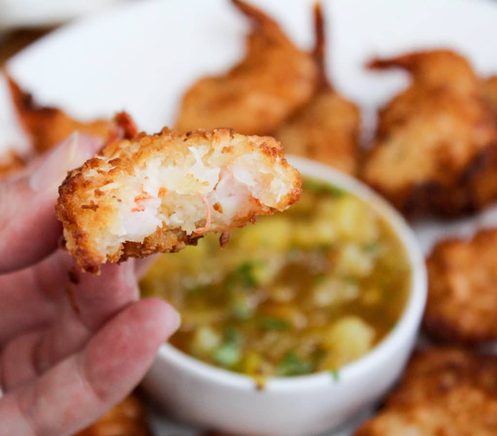 shrimp held in a hand with a bite