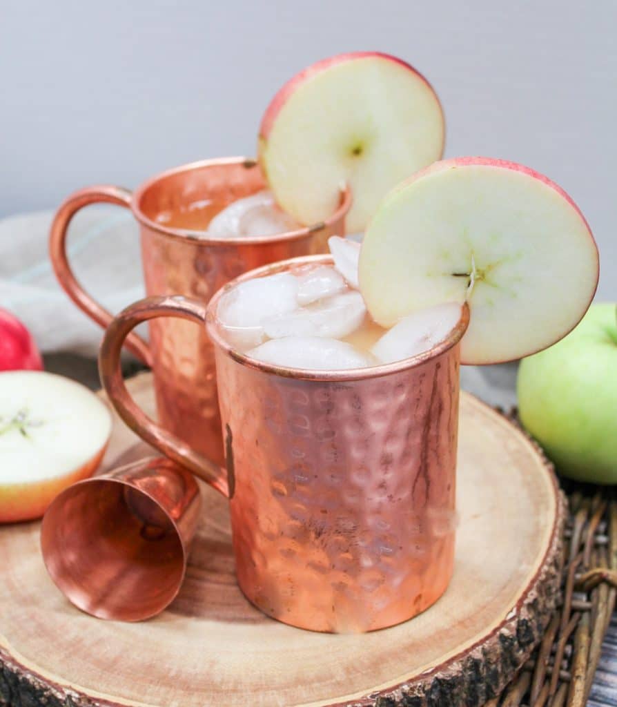 apple cider mule in a copper mug with an apple slice as a garnish