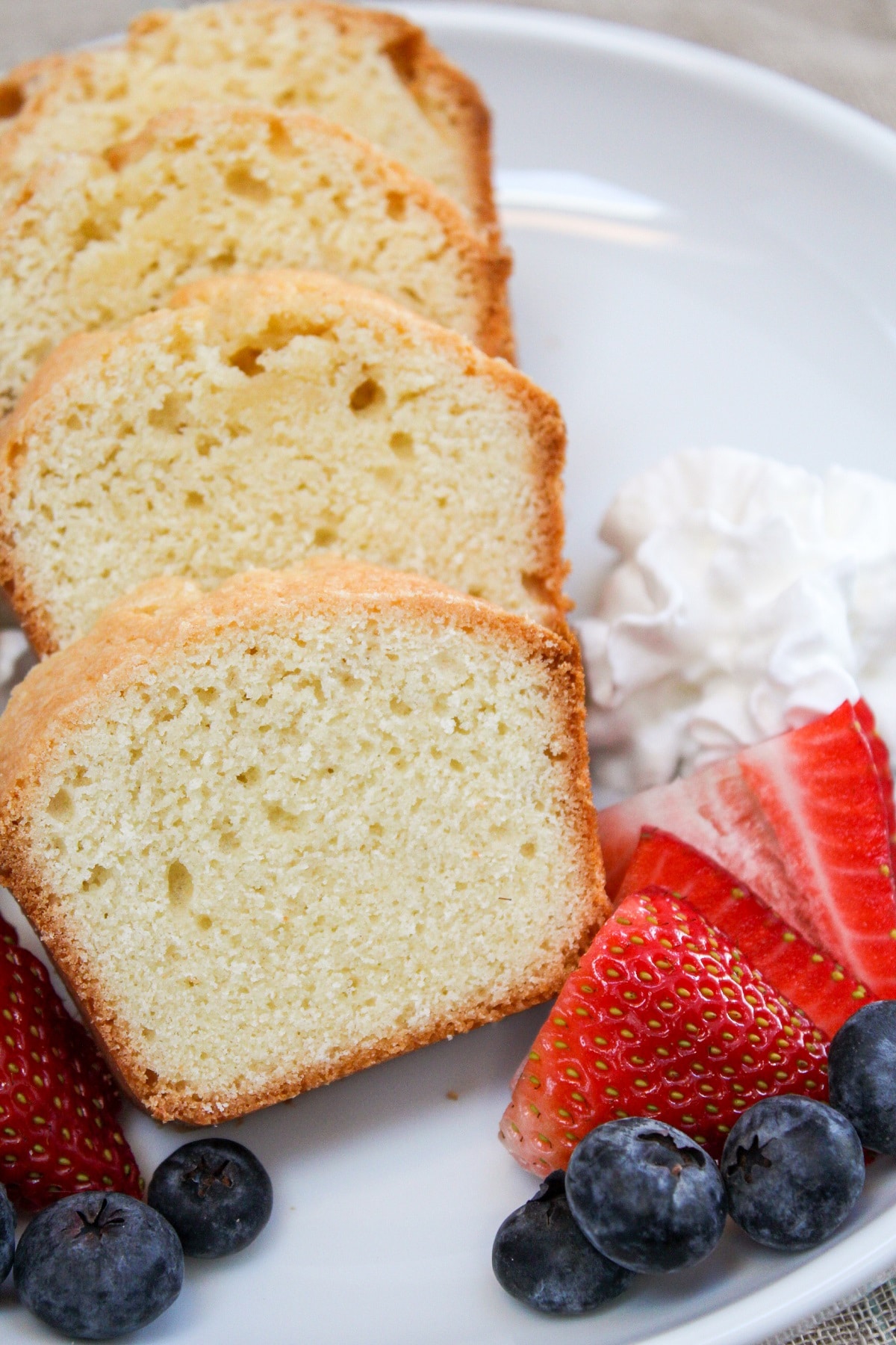 mini pound cake sliced with berries on a plate