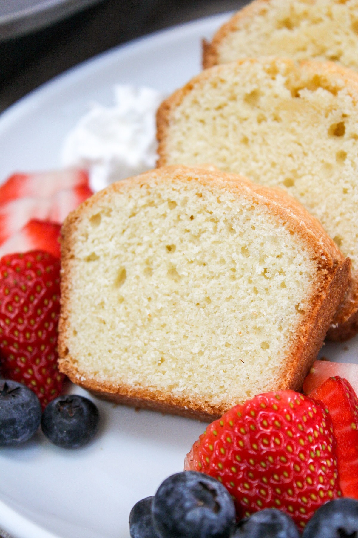 mini pound cake sliced with berries on a plate