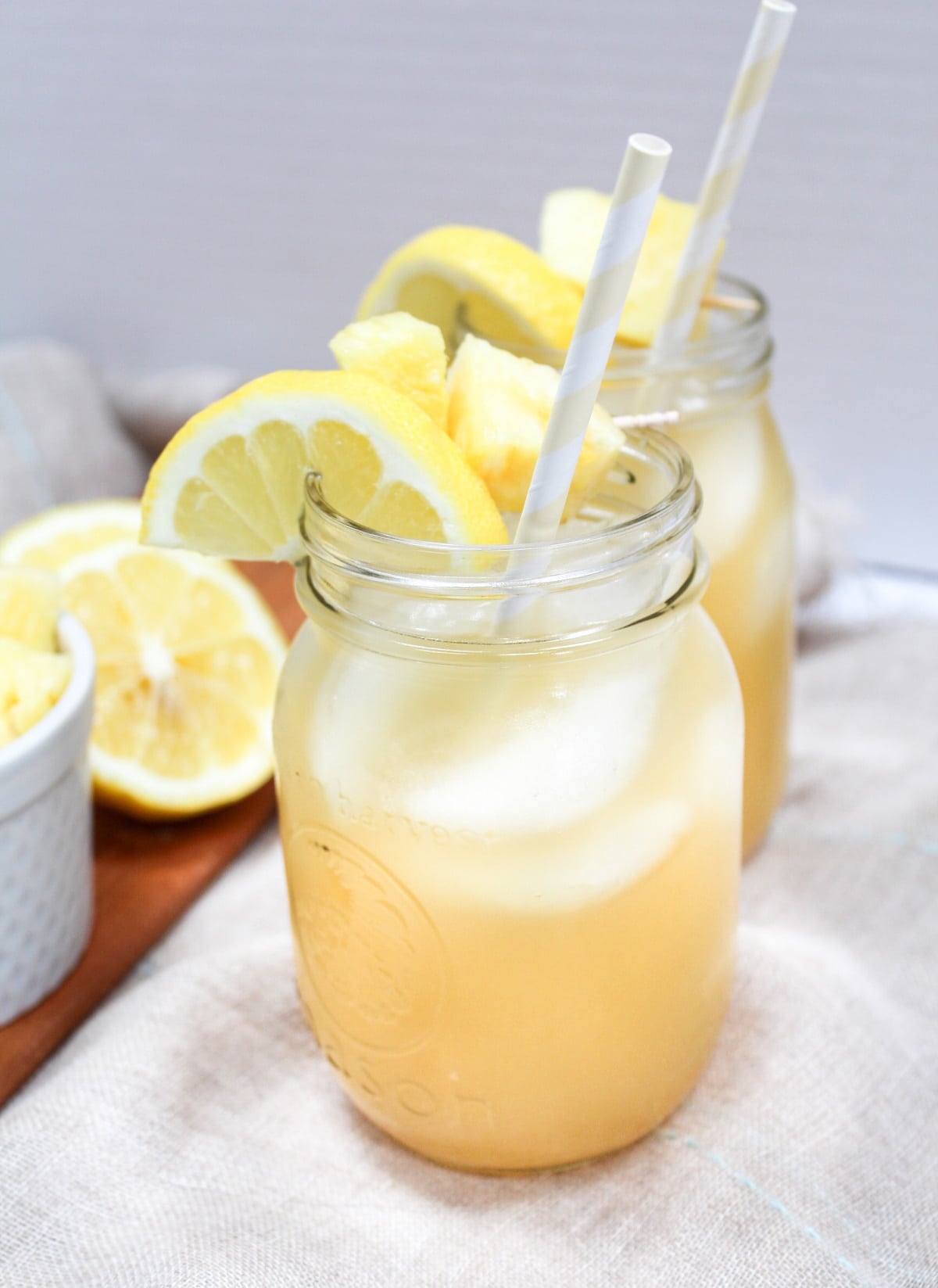 pineapple bourbon lemonade in glass with pineapple and lemon garnish