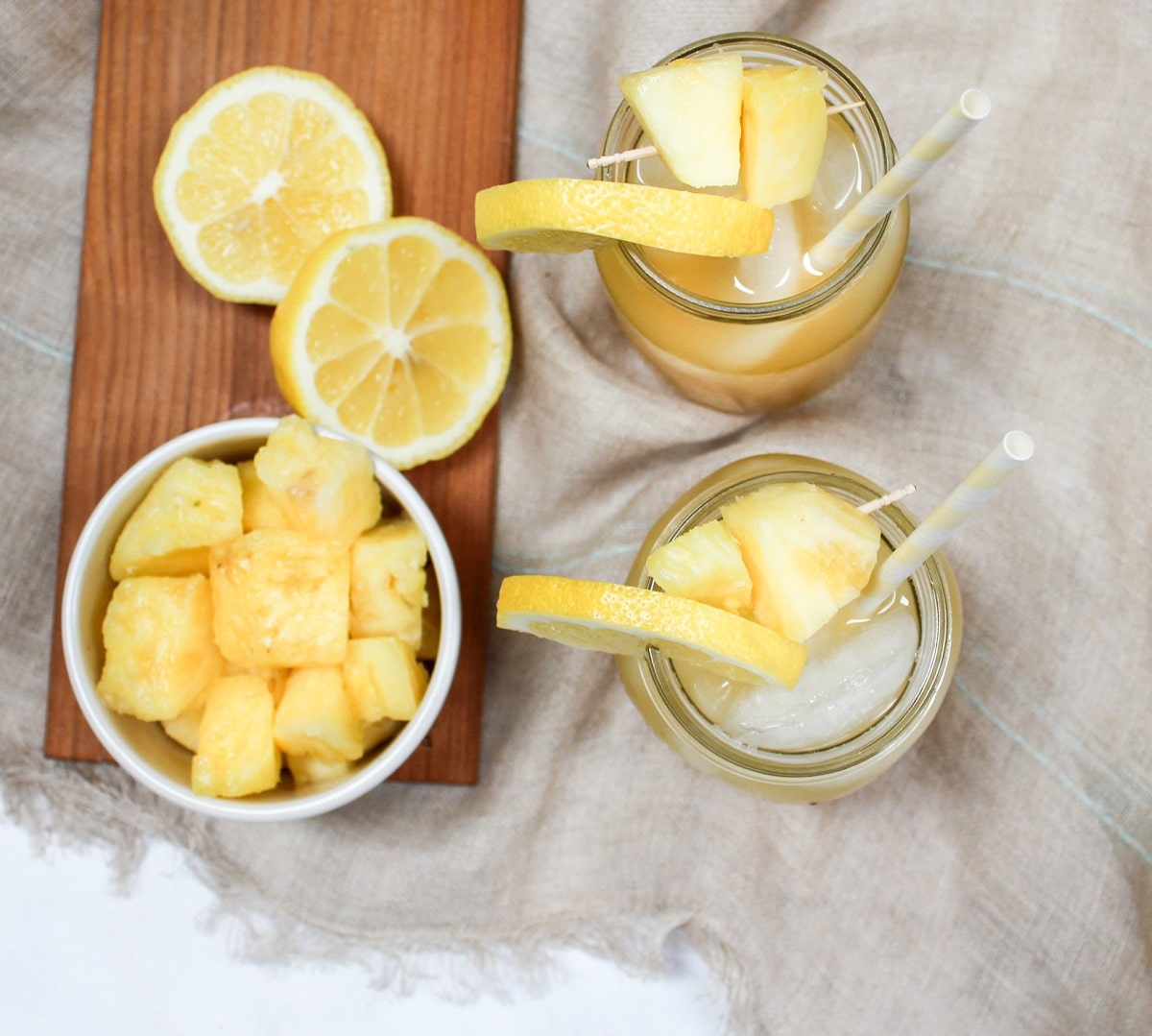 pineapple bourbon lemonade in glass with pineapple and lemon garnish overhead photo