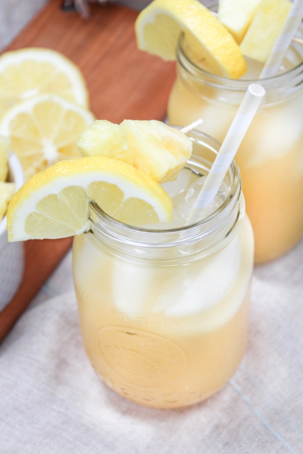 pineapple bourbon lemonade in glass with pineapple and lemon garnish