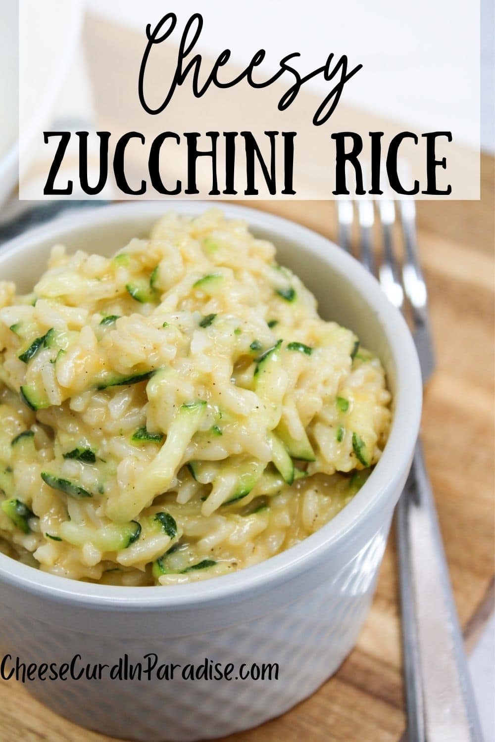 cooked cheesy zucchini rice in a bowl with a fork on the side
