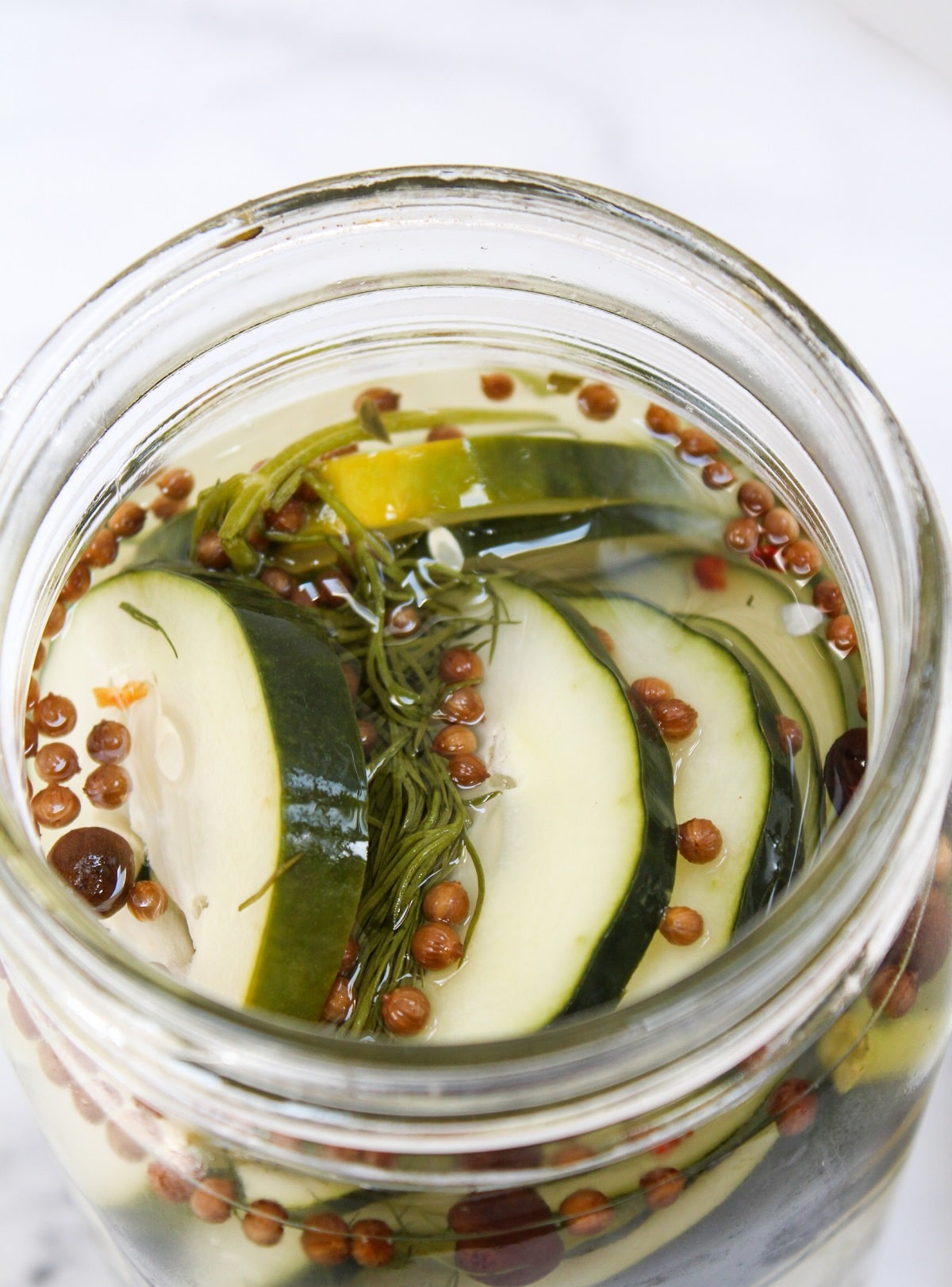 sliced easy refrigerator dill pickles in an unsealed glass jar 
