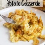 cheesy potato casserole on a white plate with a fork