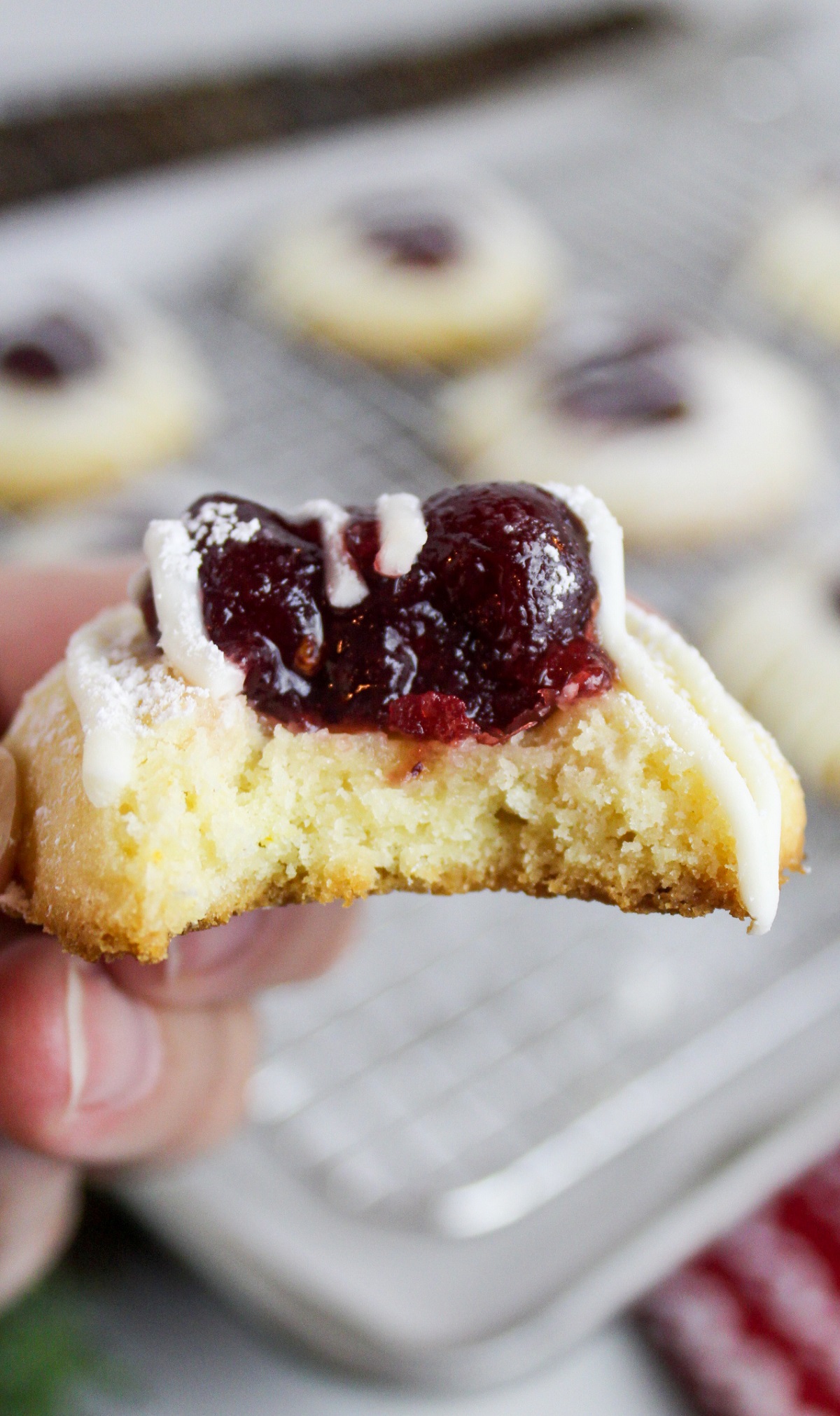 cranberry thumbprint cookies on a baking sheet with bite