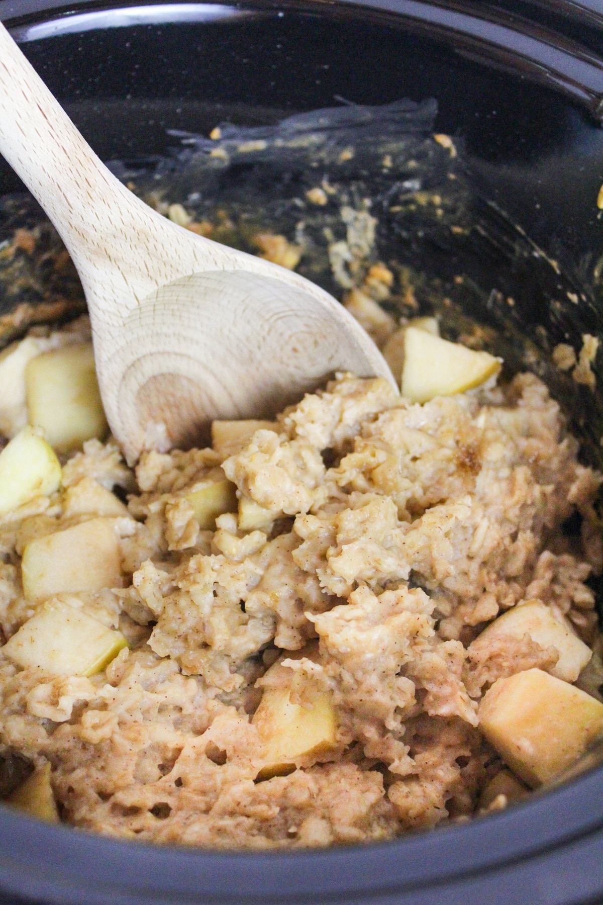slow cooker apple cinnamon oatmeal with a spoon in a slow cooker