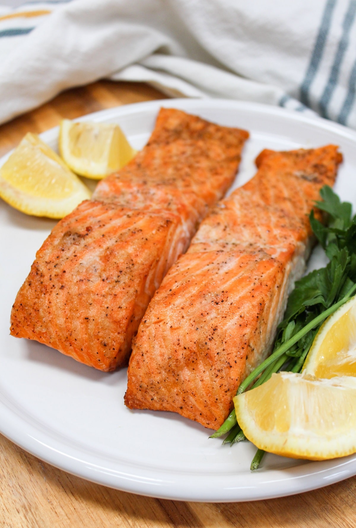 salmon on a white plate with lemons.