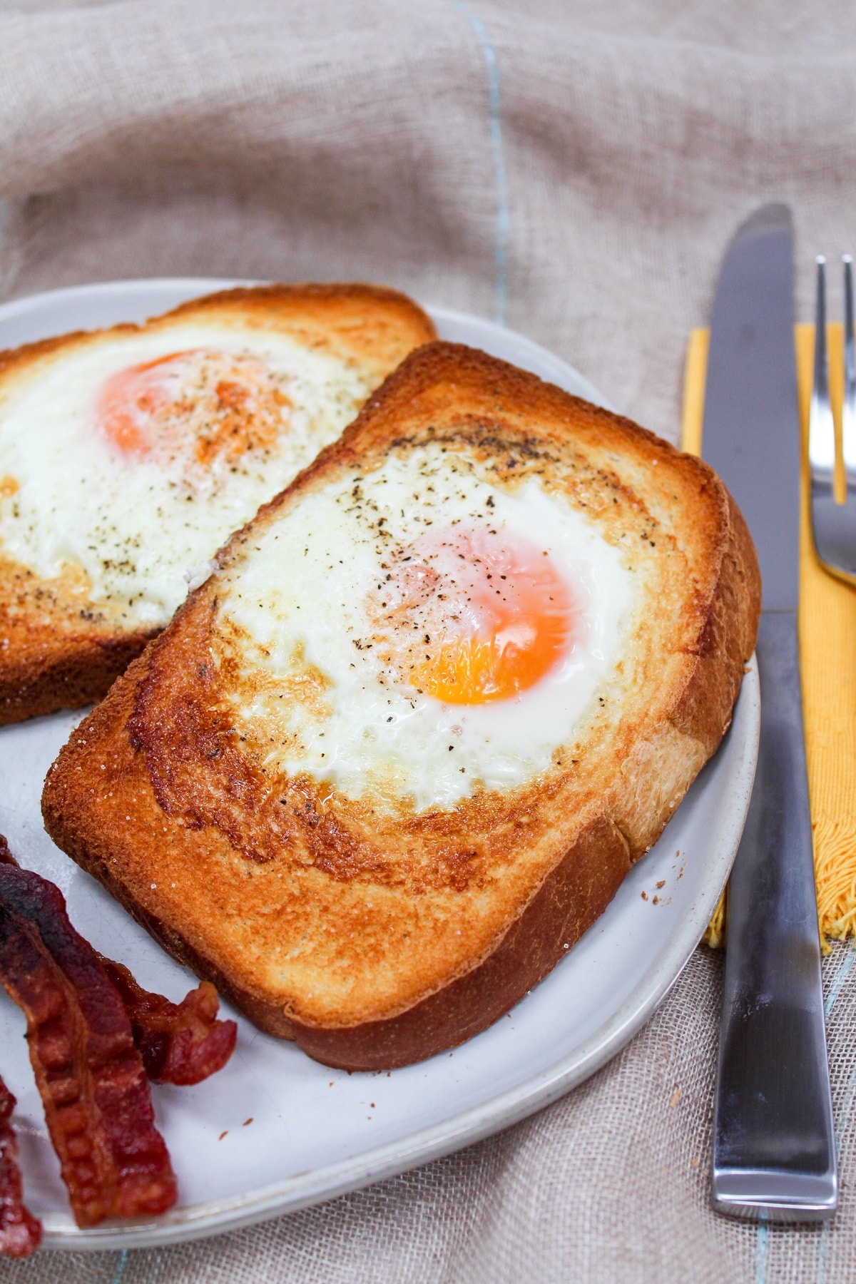 air fryer egg toast on a plate with bacon
