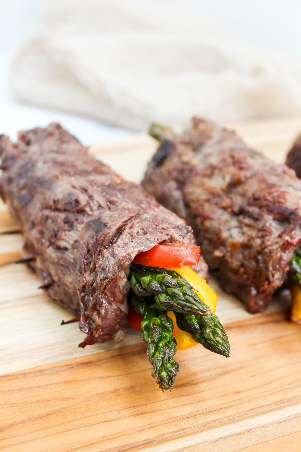 steak and asparagus roll-ups on a cutting board