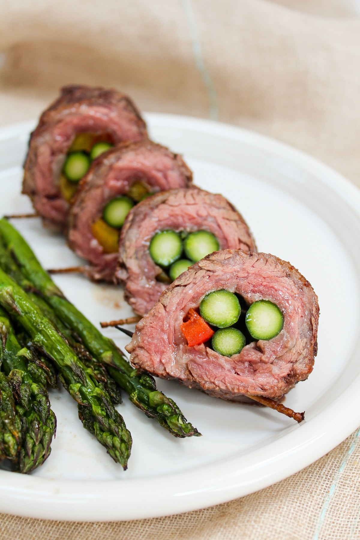 steak and asparagus roll-ups sliced on a plate