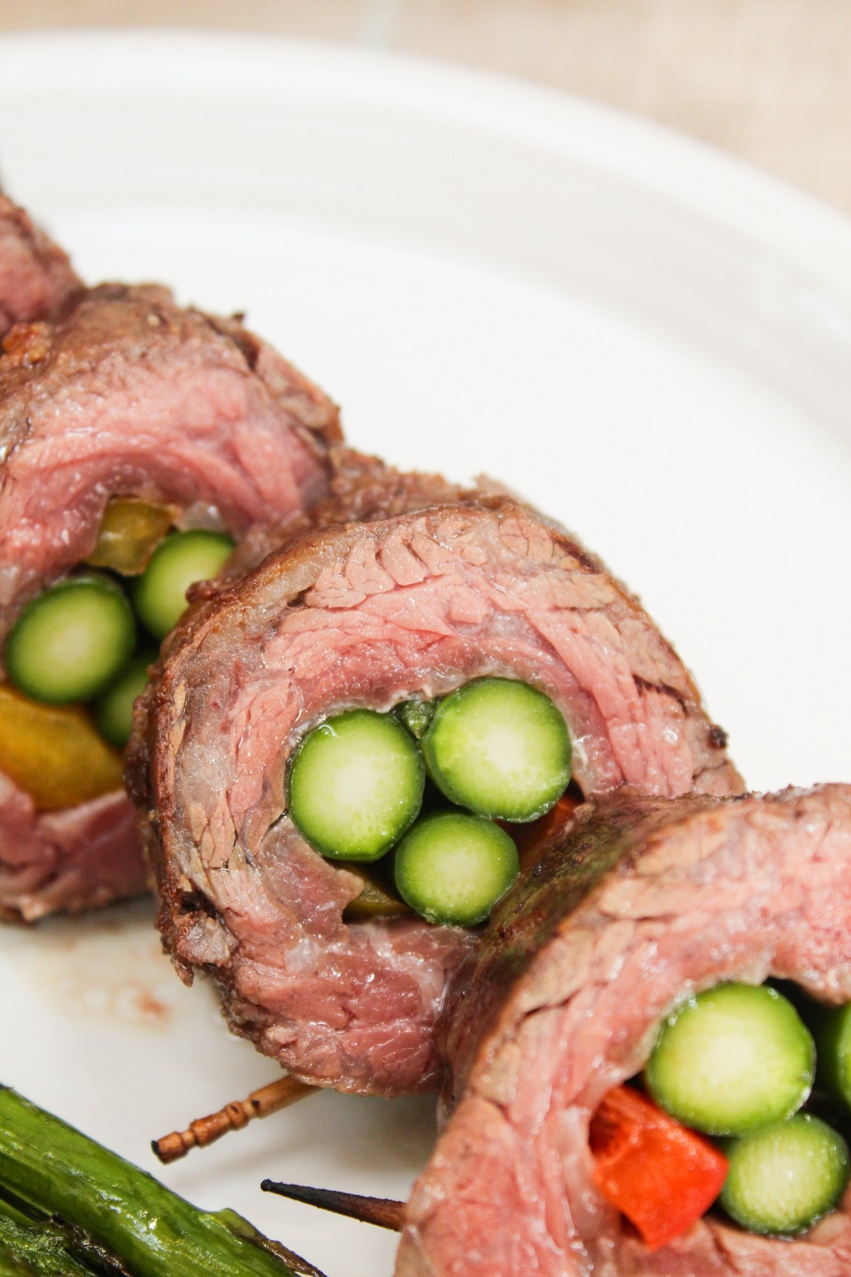steak and asparagus roll-ups sliced on a plate