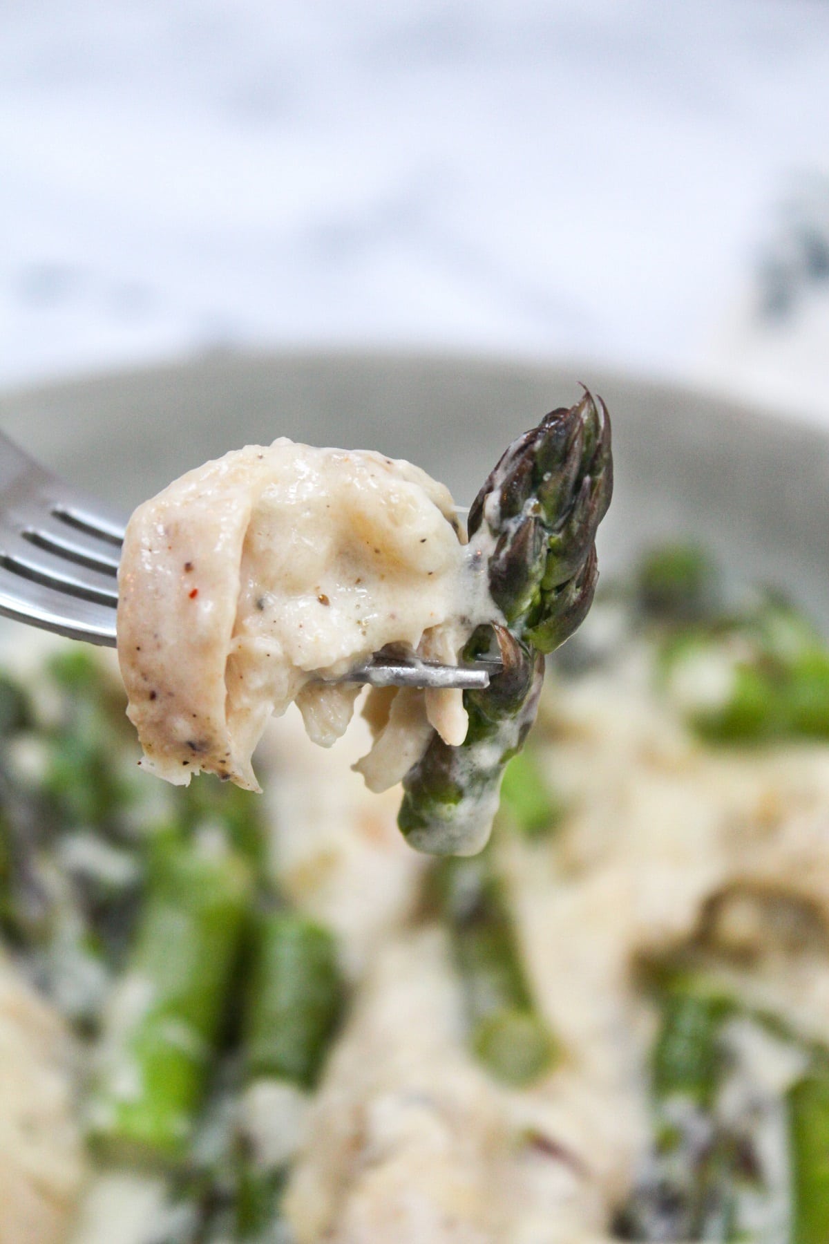 creamy keto chicken and asparagus  on a fork.