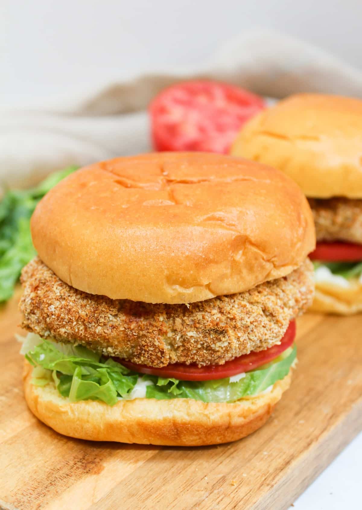 crispy chicken patty on a bun with shredded lettuce and sliced tomato.