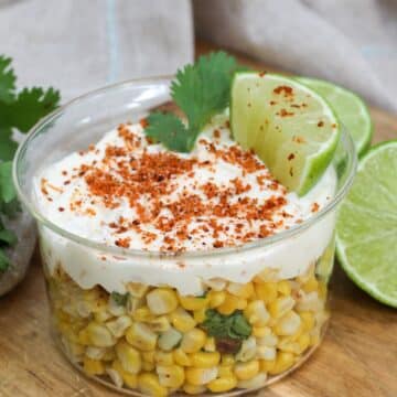 Mexican Street Corn Elote Bowl in a glass dish with lime and cilantro on top.