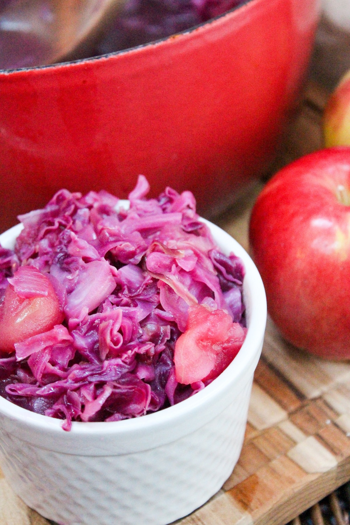 chopped red cabbage and apples in a small white dish.