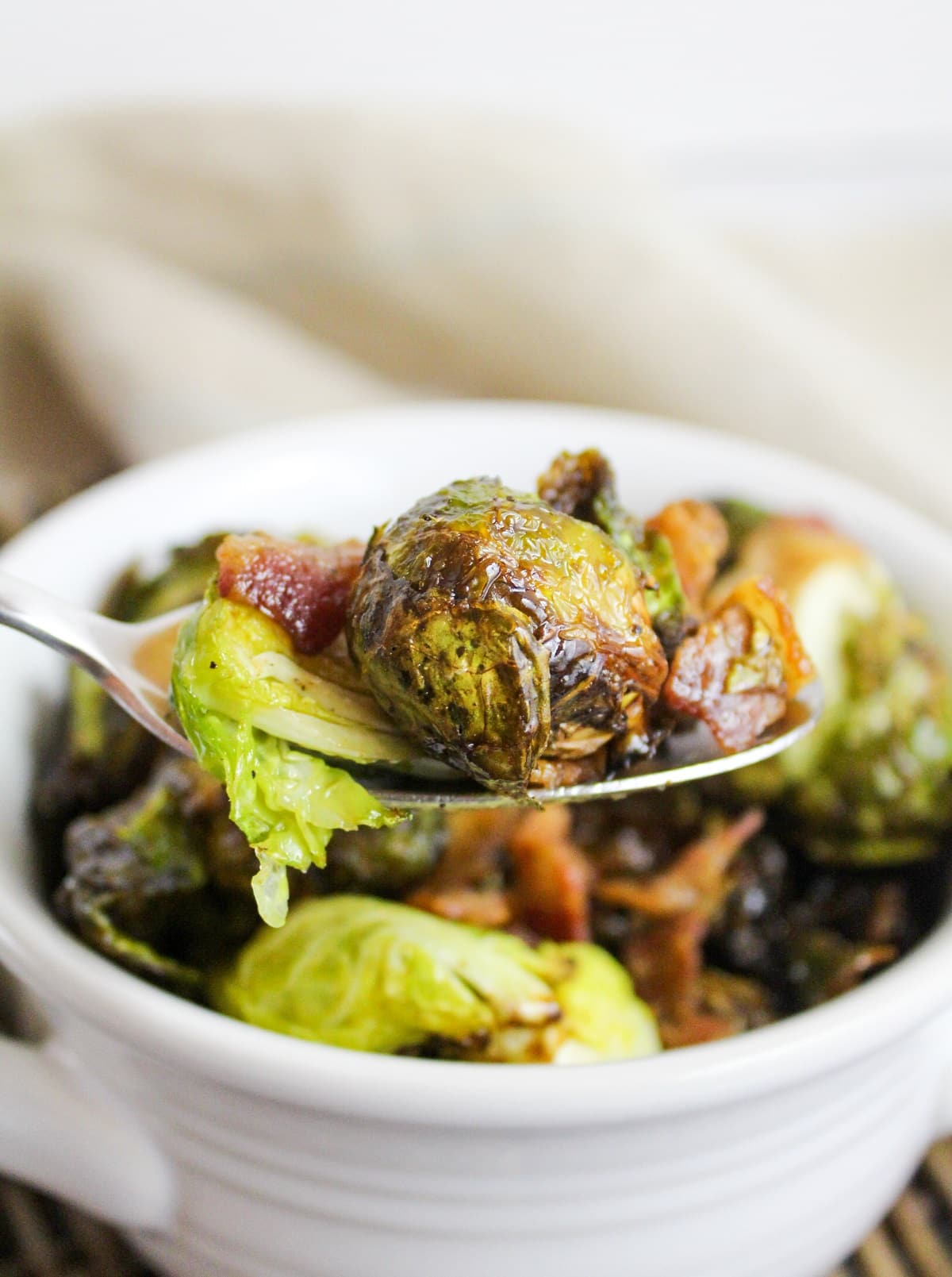 cooked brussels sprouts and bacon on a spoon.