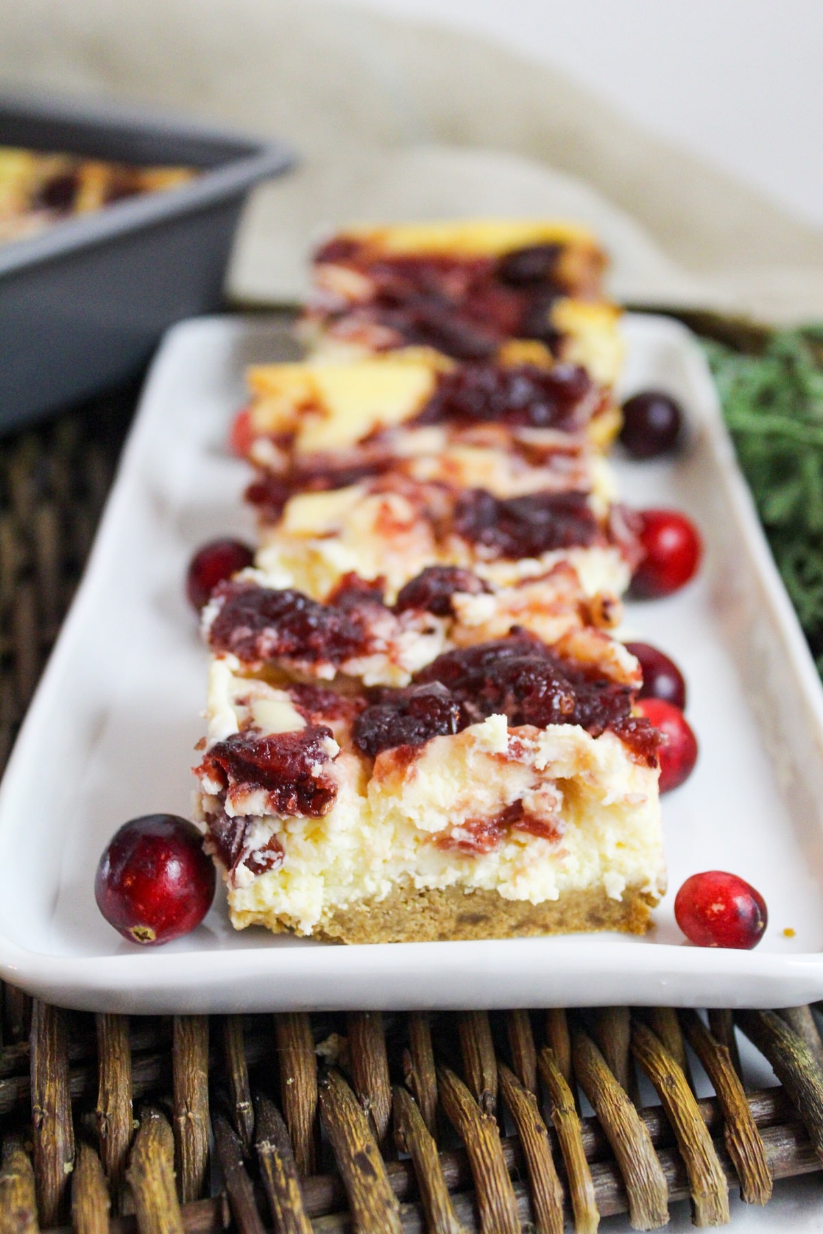 Cut bars of vanilla cheesecak2 with a cranberry swirl on a plate.